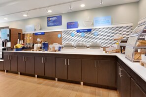 Un buffet pour le petit-déjeuner proposant une variété d’aliments, notamment des céréales et des plats chauds, ainsi qu’un panneau indiquant qu’il s’agit d’un petit-déjeuner rapide.