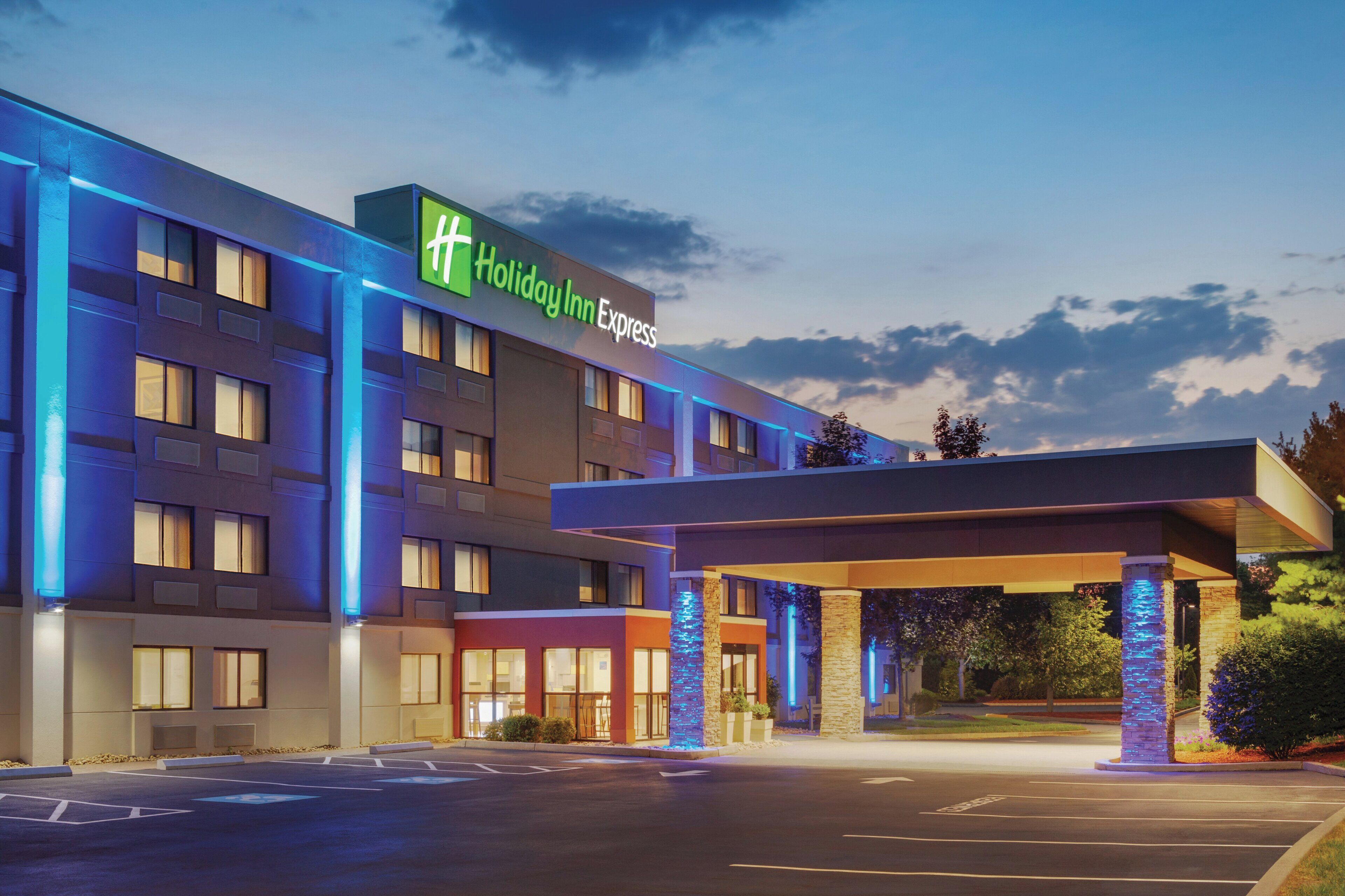 A Holiday Inn Express hotel with a modern facade, a covered entrance, and a parking lot.