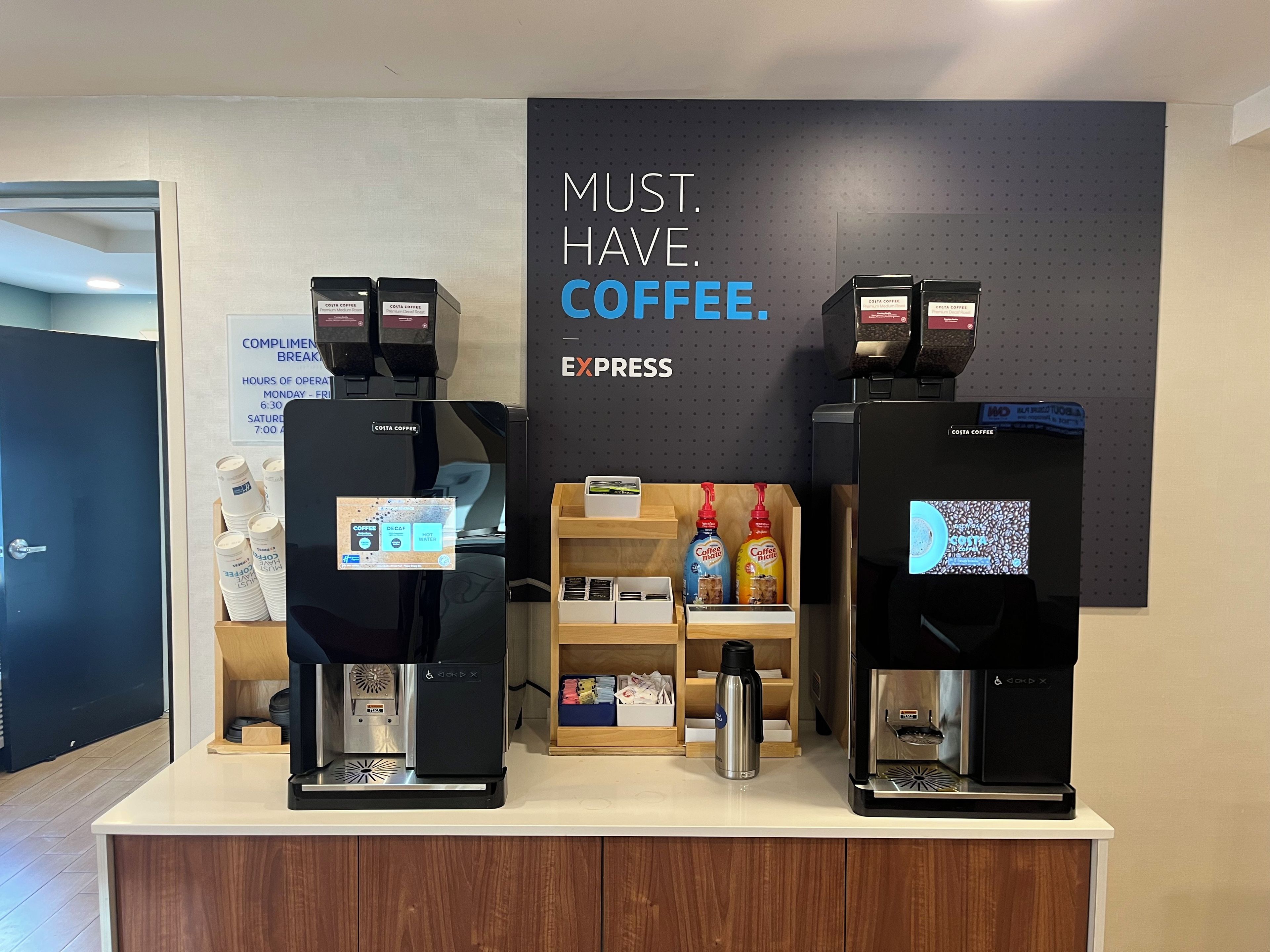 Two coffee machines with a sign above stating 'MUST. HAVE. COFFEE. EXPRESS.'