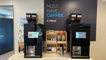 Två kaffemaskiner med en skylt ovanför som lyder: ”KAFFE. MÅSTE. FINNAS. SNABBKAFFE.”