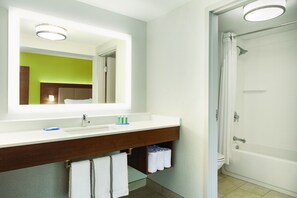 Ein Badezimmer mit einem weißen Waschbecken, Spiegel und Dusche.