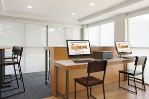 Un espacio de oficina moderno con dos escritorios, cada uno con una computadora y teclado, y dos sillas.