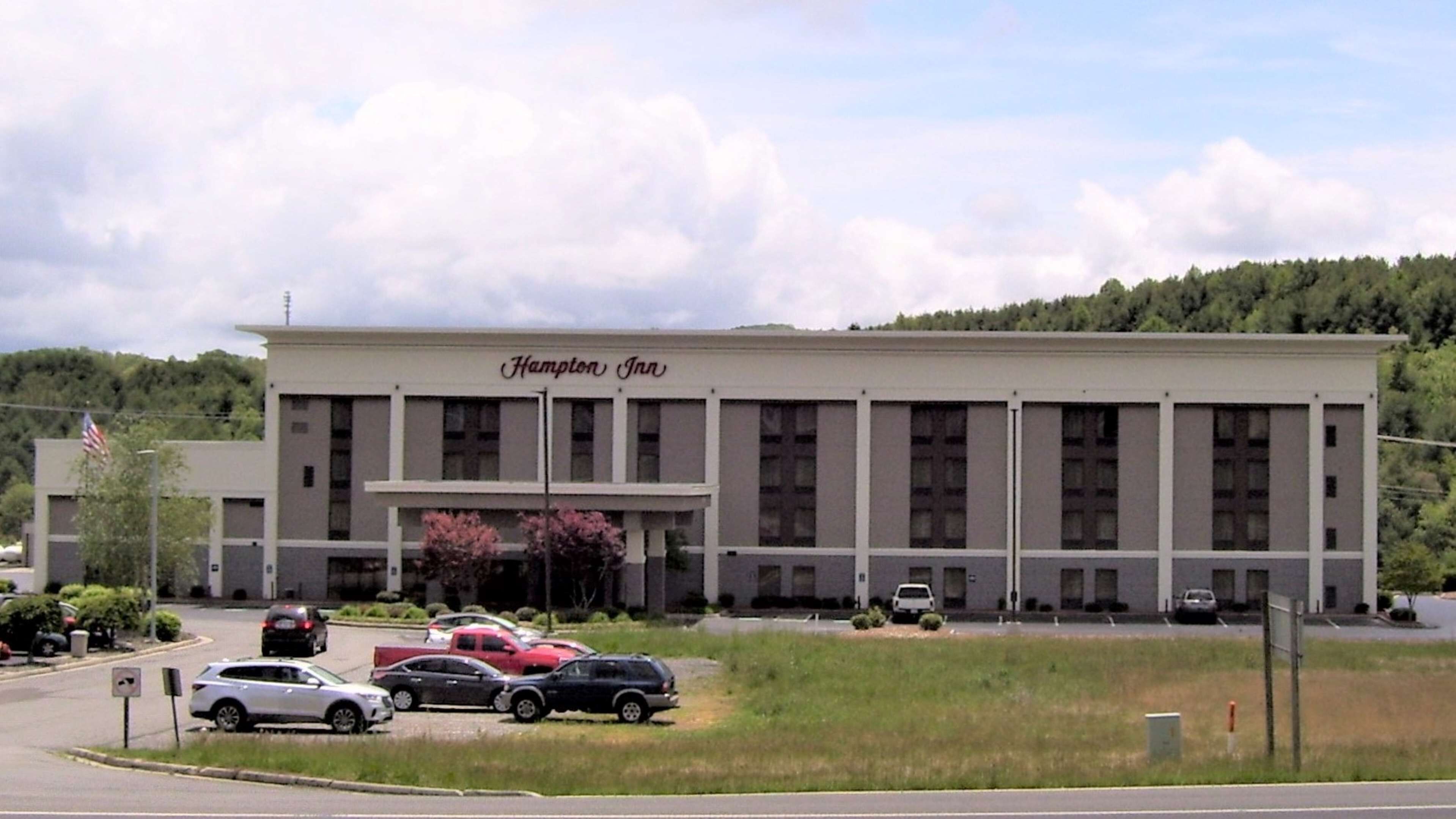 A Hampton Inn building with a parking lot in front.