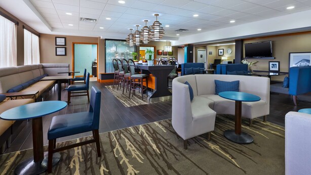 A hotel lobby with seating areas, a bar, and a television. - Hampton Inn Marysville (Marysville)