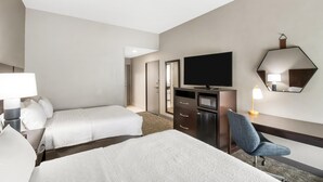 A hotel room with two beds, a TV, a desk with a chair, a lamp, and a mirror. - Hampton Inn Milledgeville (Milledgeville)