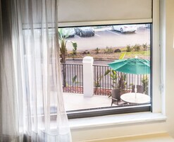Una ventana con vistas a un estacionamiento y una zona de estar al aire libre.