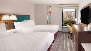 A hotel room with two beds, a desk, a TV, and a window with a view of trees. - Hampton Inn Athens (Athens)