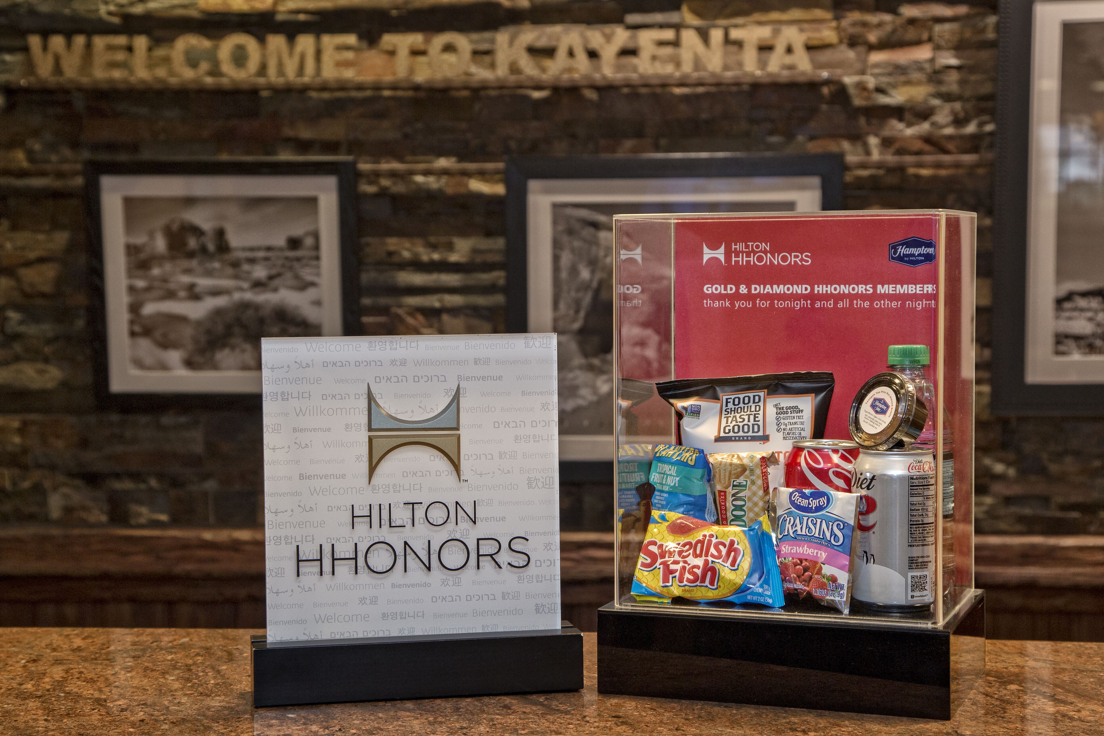 A display of Hilton Honors gifts including snacks and a can of soda.