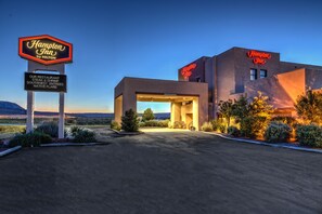 A Hampton Inn by Hilton with a signboard advertising steak, shrimp, and native flake entrees.