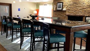Uma sala de conferências com uma mesa comprida, cadeiras e uma parede de pedra.