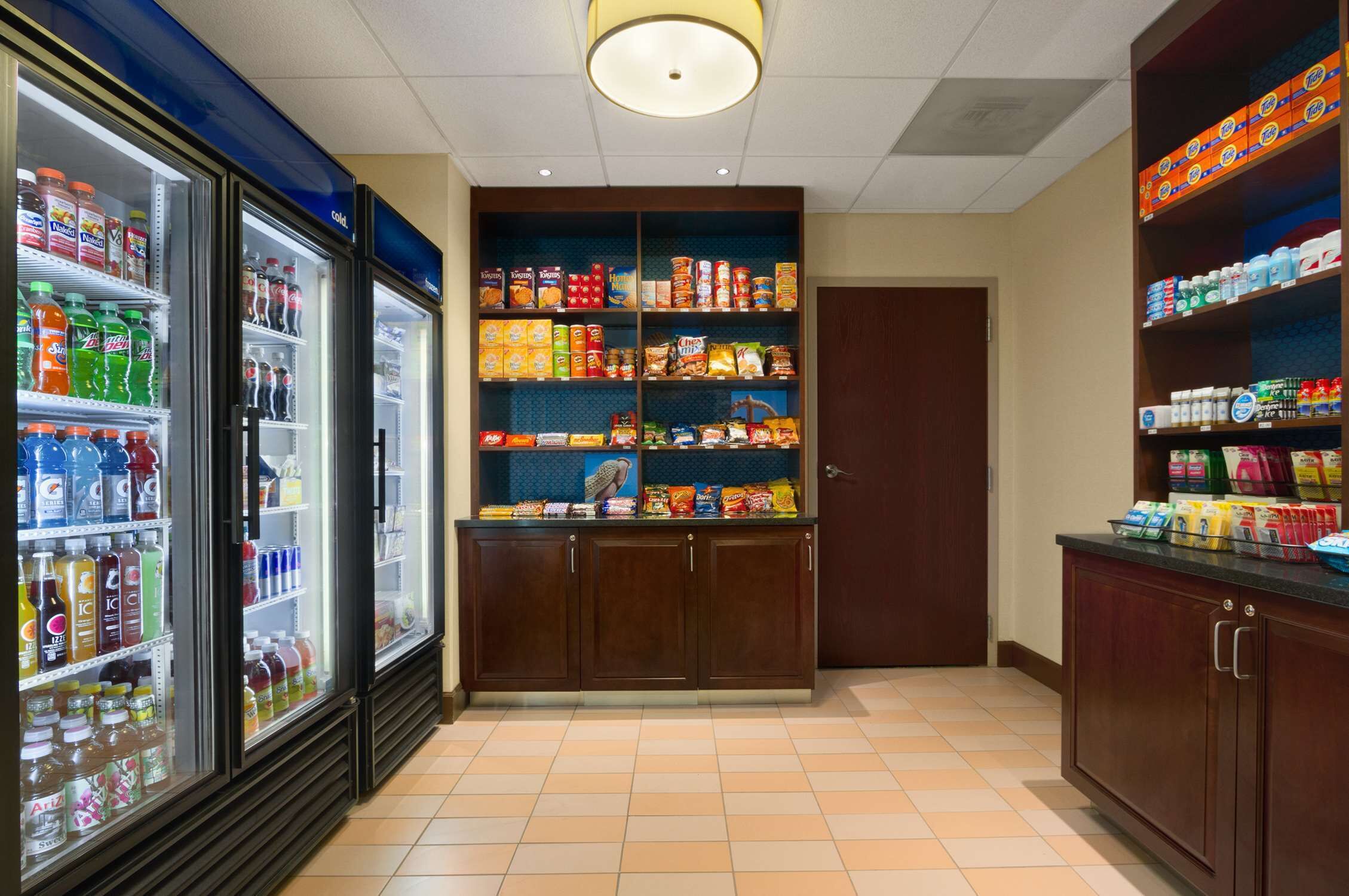 Un garde-manger d’hôtel contenant des boissons fraîches, des en-cas et des articles de toilette.