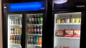 Two refrigerated display cases in a store, one labeled 'cold' and the other 'frozen', containing various beverages and food items. - Hampton Inn by Hilton Lexington Park (Lexington Park)