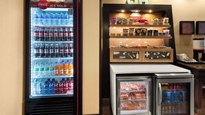 A vending machine with various beverages and a display case with baked goods. - Hampton Inn Lancaster (Lancaster)