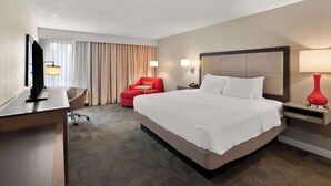 A hotel room with a large bed, a desk, a red armchair, and a TV. - Hampton Inn Lancaster (Lancaster)