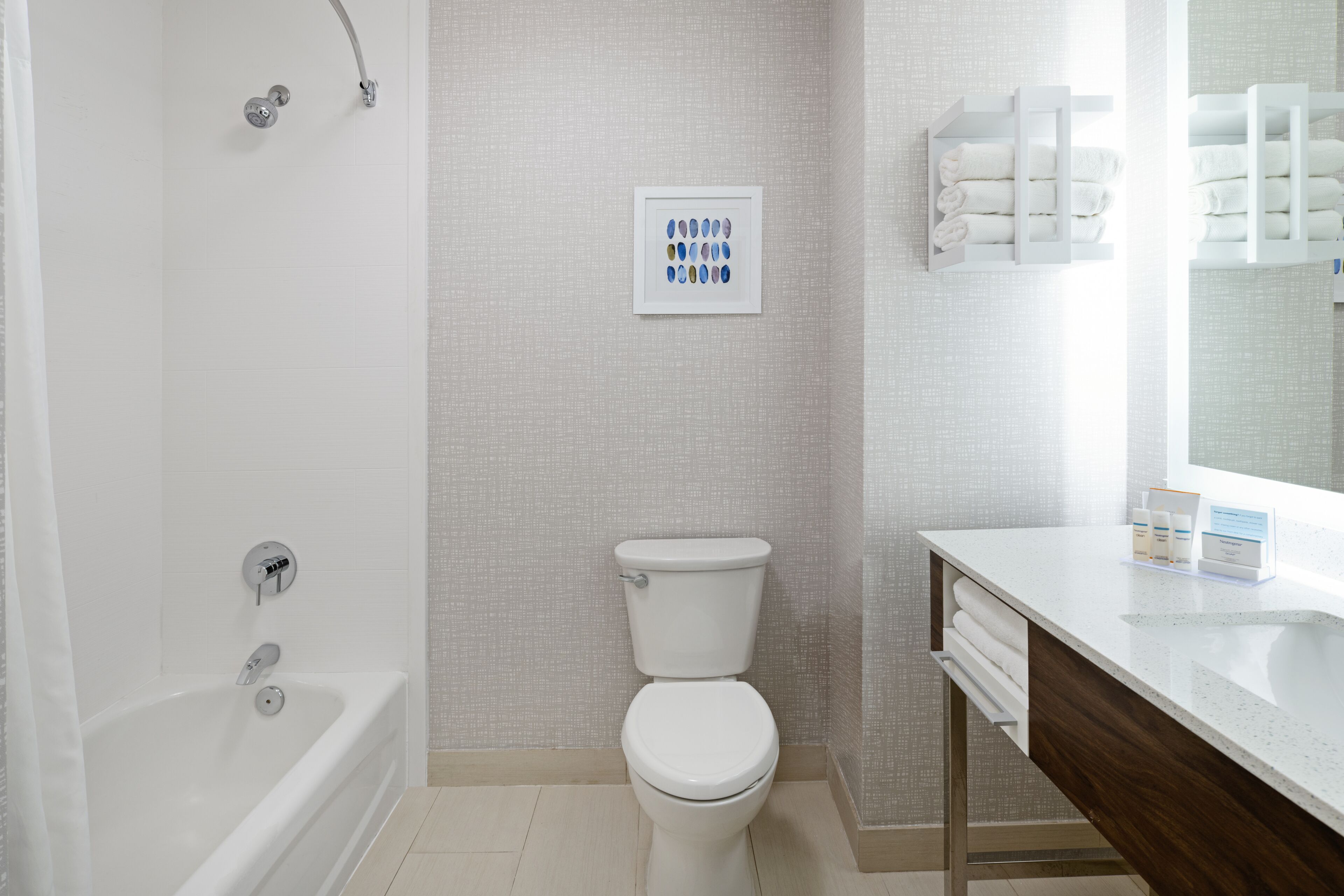 Une salle de bain moderne équipée d’une baignoire, de toilettes et d’un meuble-lavabo avec un miroir.