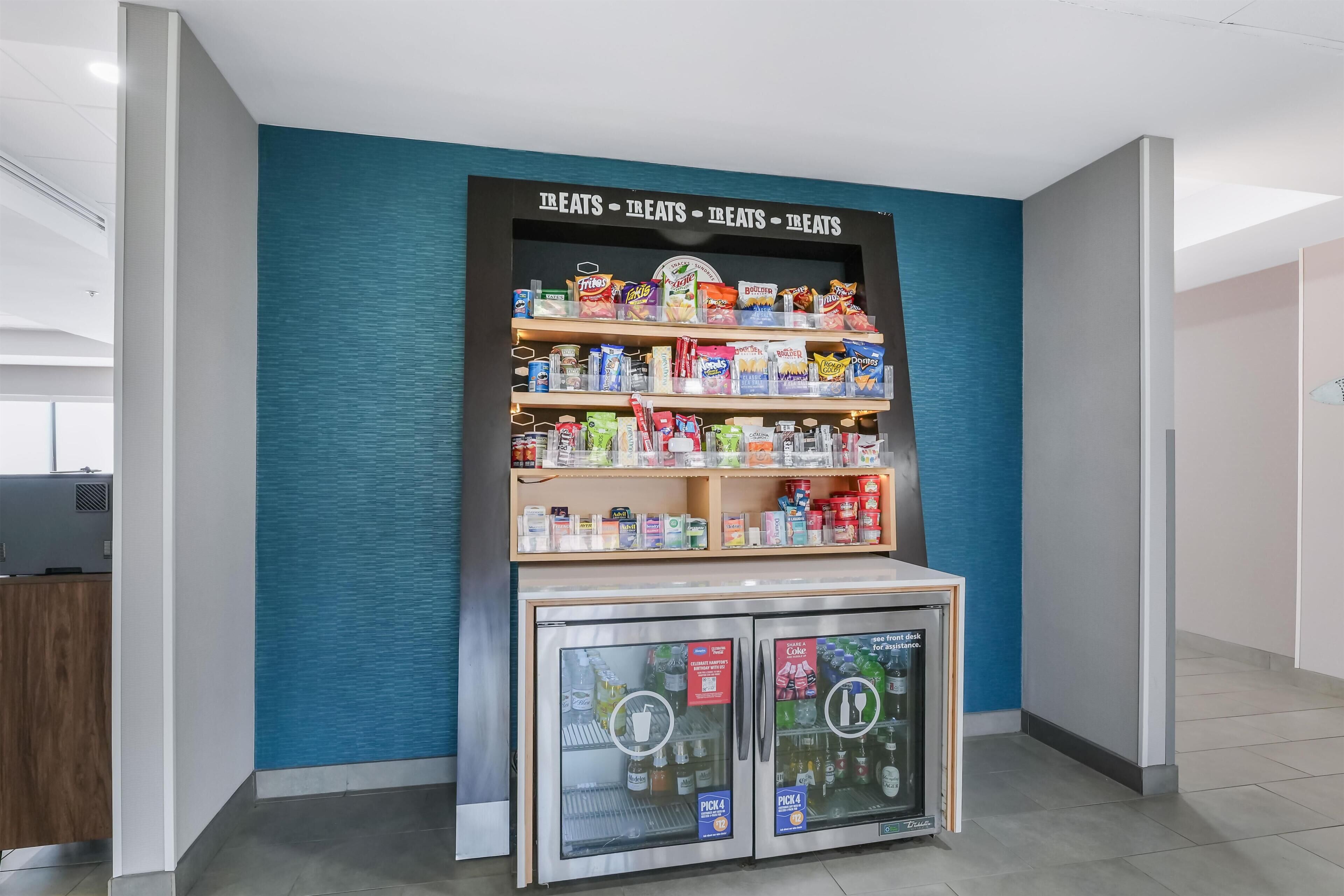 Máquina expendedora con aperitivos y bebidas, en un espacio interior moderno.