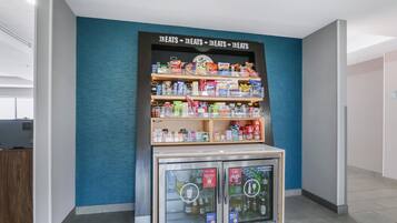 Máquina expendedora con aperitivos y bebidas, en un espacio interior moderno.