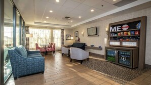 A hotel lobby with a seating area, a snack bar, and a refrigerator.