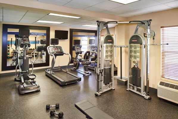 A gym with treadmills, elliptical machines, weight machines, and dumbbells. - Hampton Inn & Suites Chapel Hill/Durham, Area (Chapel Hill)