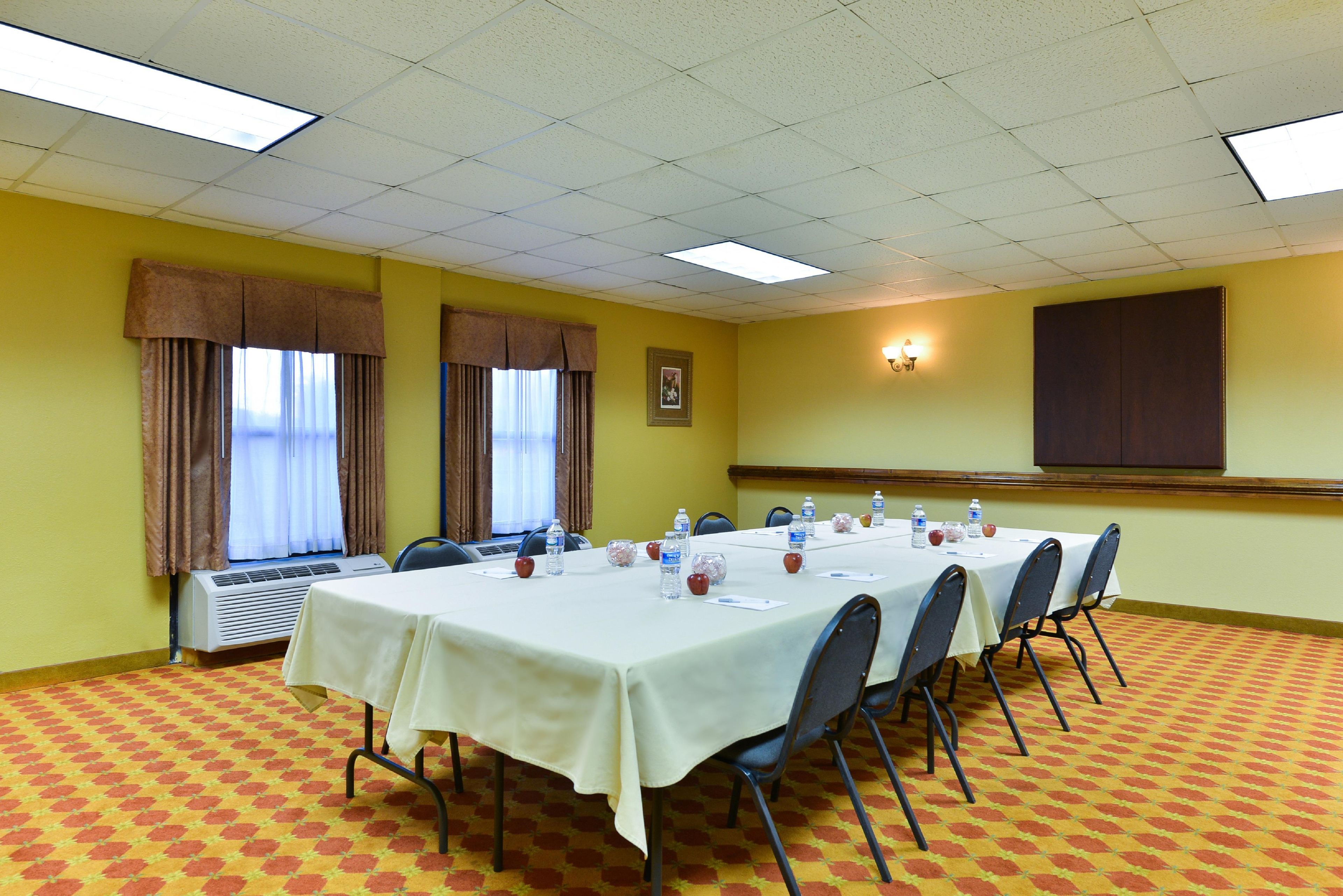 Une salle de conférence équipée d’une longue table, de chaises et d’un écran de projection.