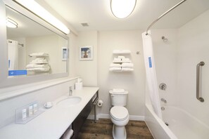 A modern bathroom with a sink, toilet, and bathtub.