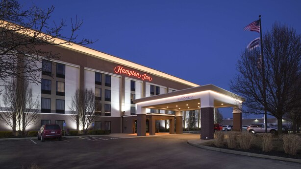 A Hampton Inn hotel with a well-lit entrance and a covered parking area.