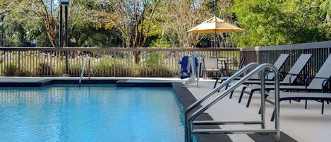 Una piscina al aire libre, sombrillas