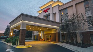 A Hampton Inn hotel entrance with a 'Welcome' sign, a covered entrance, and a parking area. - Hampton Inn Tallahassee-Central (Tallahassee)