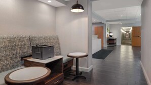 A modern hotel lobby with a seating area, a reception desk, and a hallway leading to other rooms. - Hampton Inn Tallahassee-Central (Tallahassee)