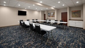 A conference room with a long table, chairs, a flat-screen TV, artwork on the wall, and a carpeted floor. - Hampton Inn Winfield/teays Valley (Hurricane)