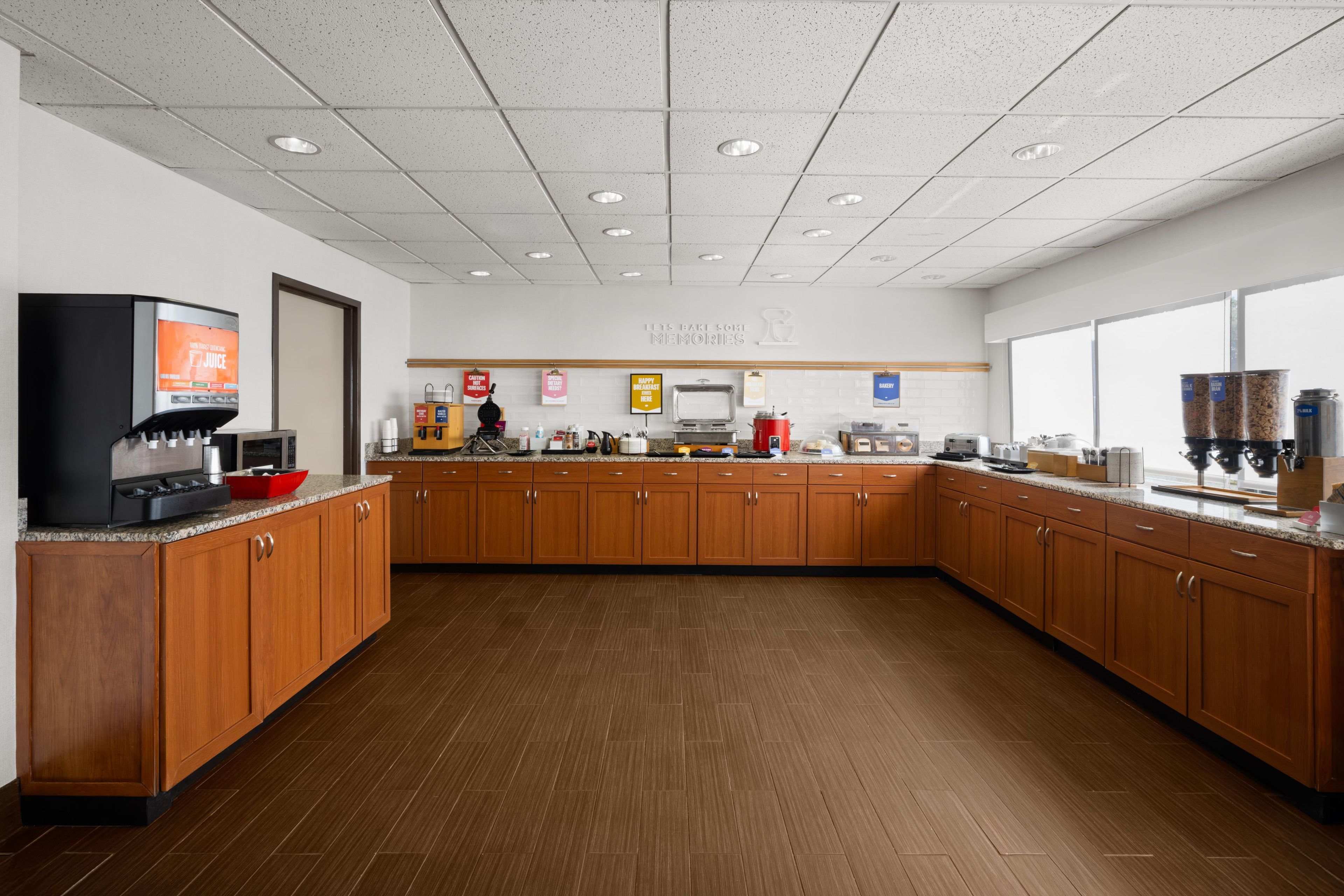 A spacious kitchen area with wooden cabinets, a coffee machine, and a breakfast bar.