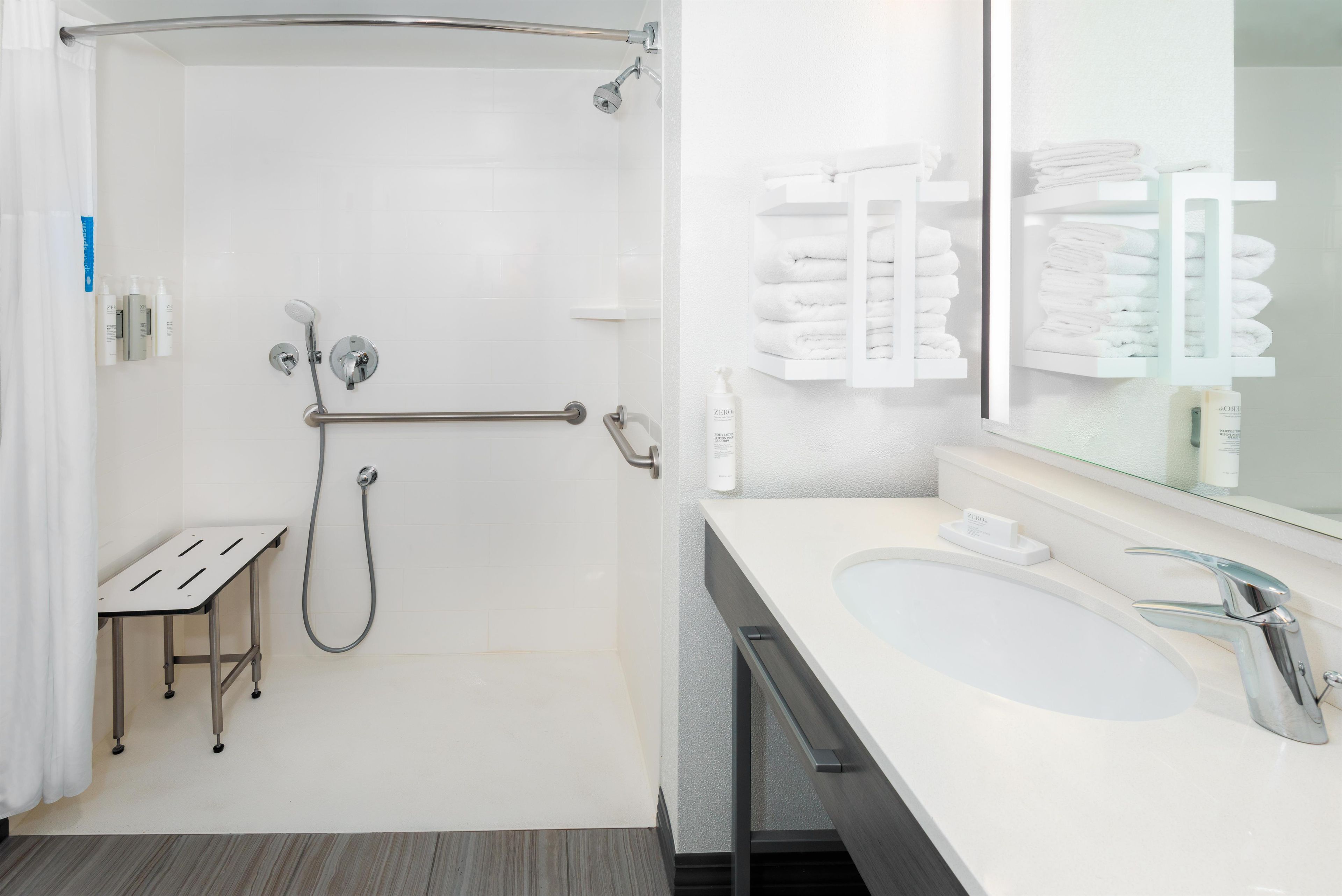 Une salle de bain moderne avec une douche à l’italienne, un meuble-lavabo et un porte-serviettes.