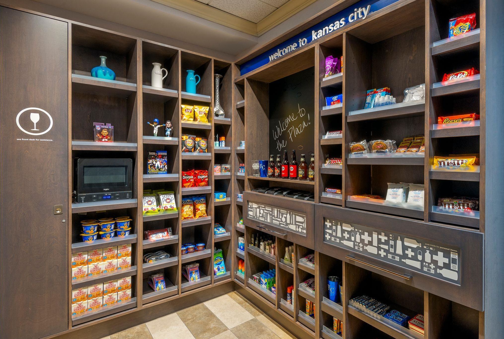 A well-organized pantry with various food items and a chalkboard sign welcoming visitors to Kansas City.