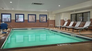 An indoor swimming pool with clear water, a tiled border, and a lifeguard chair. - Hampton Inn Niagara Falls (Niagara Falls)