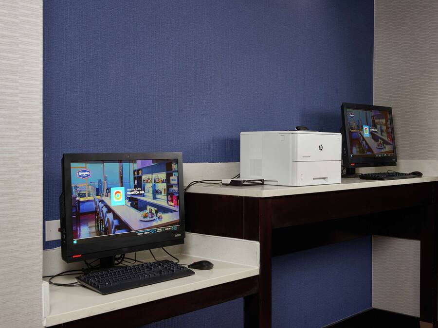 A computer setup with two monitors, a keyboard, and a mouse on a desk.