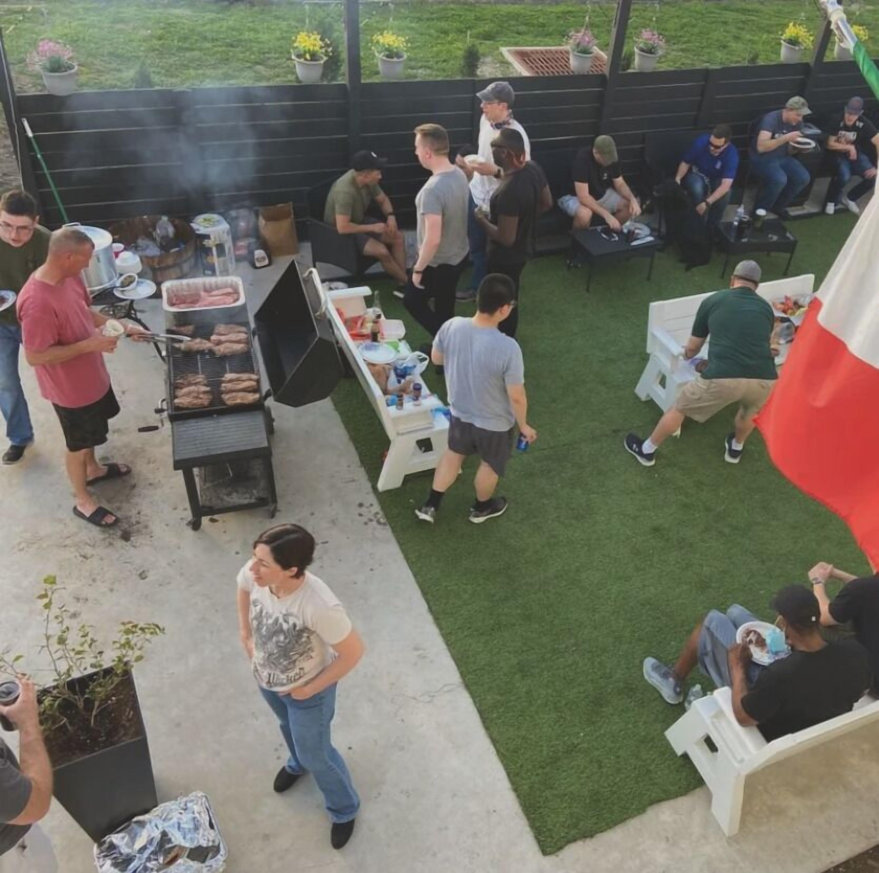 An outdoor patio area with a barbecue grill, seating arrangements, and potted plants.