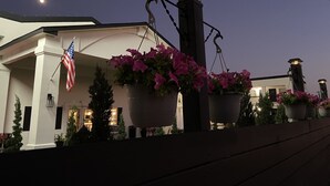 Un edificio con una bandera, plantas en macetas y un cielo nocturno.