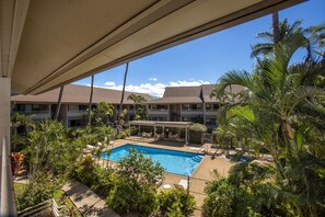 Un hotel con piscina circondato da palme e vegetazione.