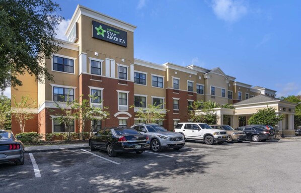 A hotel with multiple parking spaces, a sign for Extended Stay America, and a clear blue sky. - Extended Stay America Suites Orlando Maitland 1776 Pembrook (Orlando)