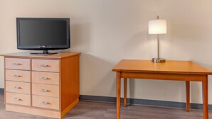 A room with a wooden cabinet with drawers, a television on top, and a table with a lamp. - Extended Stay America Suites Fort Worth Fossil Creek (Fort Worth)