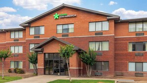 A brick building with a green logo and 'Extended Stay America' sign, multiple windows, and a visible entrance. - Extended Stay America Suites Fort Worth Fossil Creek (Fort Worth)