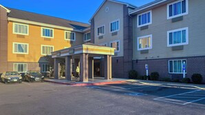 Un hôtel à plusieurs étages doté d’une entrée couverte et d’un parking.
