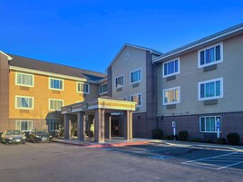 A multi-story hotel with a covered entrance and a parking lot.