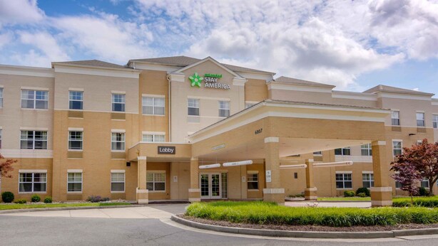 A hotel with a 'Stay America' sign, a lobby entrance, and a parking area. - Extended Stay America Suites Richmond W Broad St Glenside N (Richmond)