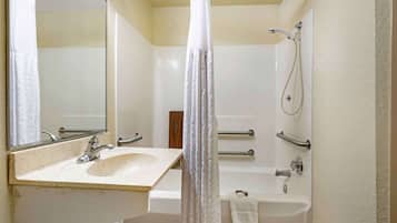 A bathroom with a sink, mirror, shower, and bathtub.