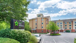 Ein Hotel mit einem Schild für Extended Stay America Suites, einem Parkplatz und einem Gebäude mit mehreren Fenstern und einem Flachdach.