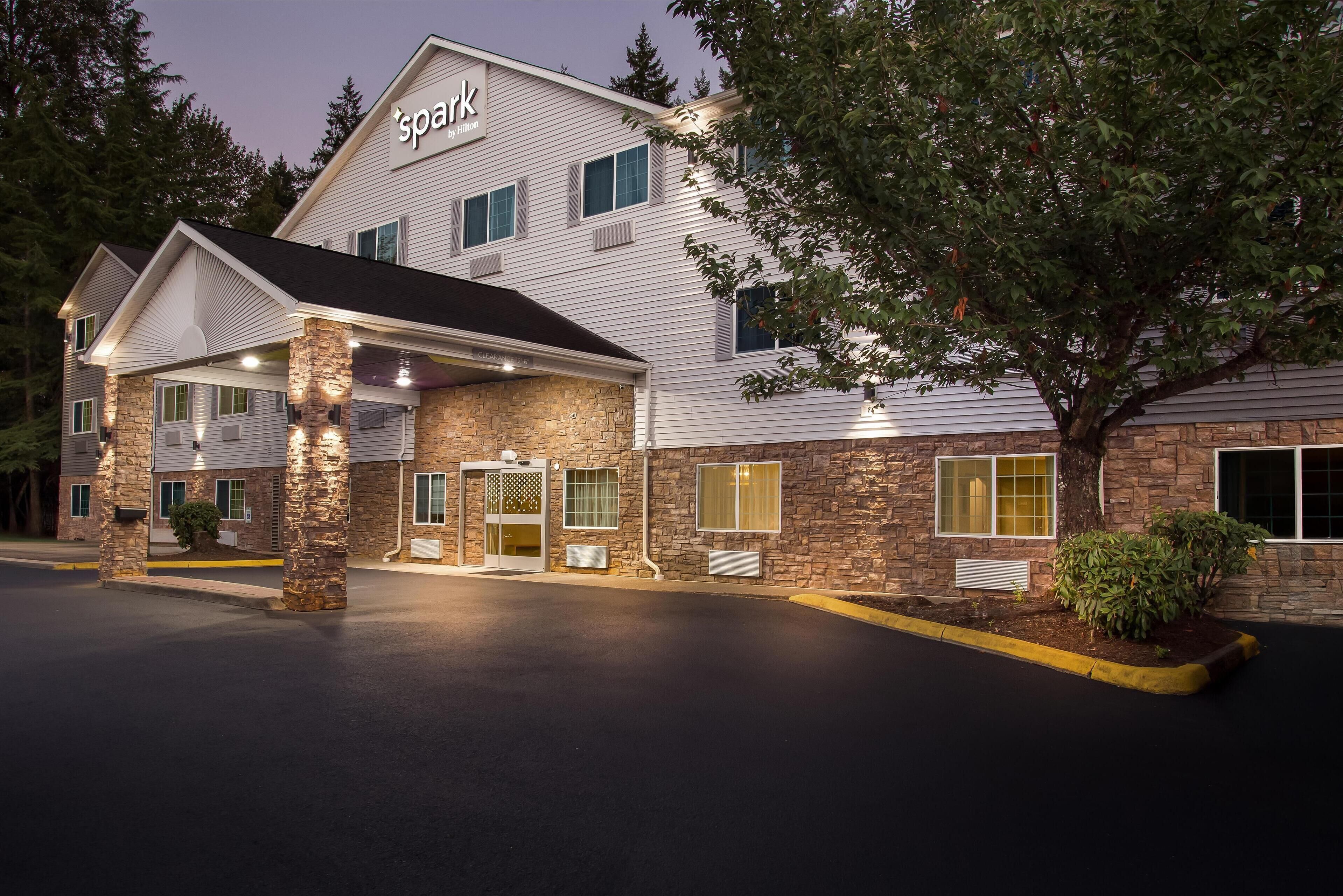 A hotel with a stone facade, a covered entrance, and a sign reading 'Spark by Horizon'.