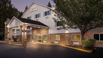 A hotel with a stone facade, a covered entrance, and a sign reading 'Spark by Horizon'.
