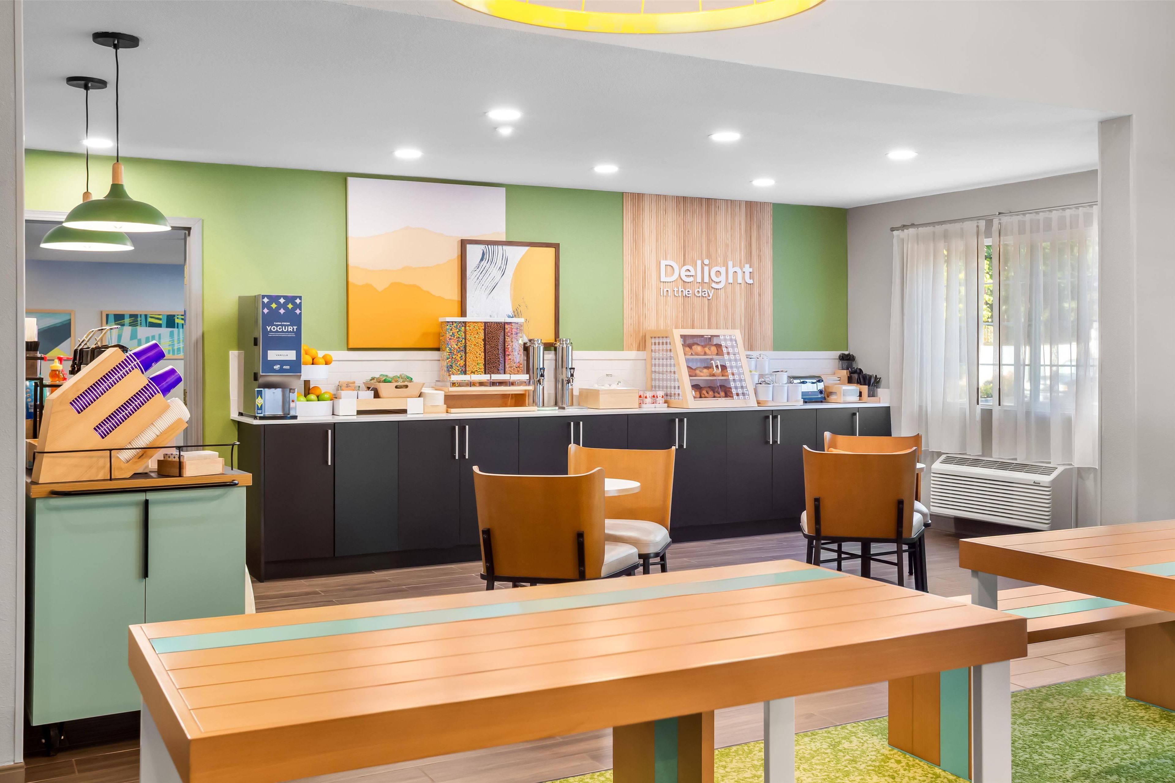 Un café moderno con mostrador, zona de estar y un cartel que dice "Delight in the day".