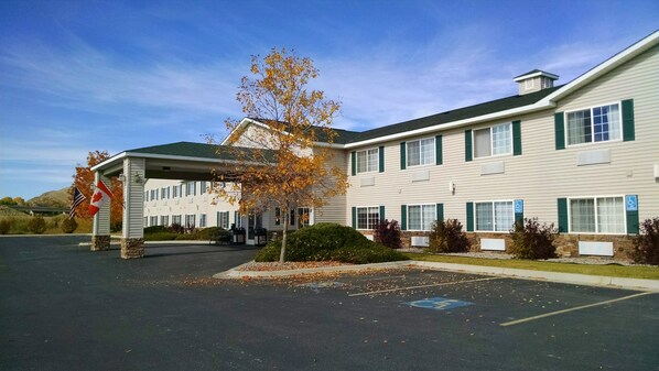 A two-story building with a covered entrance and a parking lot.
